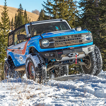 AFN 4x4 Accessories Front Bumper on a Custom Blue Off-Road Vehicle in Snowy Terrain